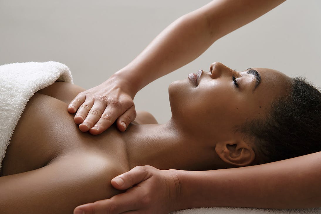 person being massaged on table in a white towel